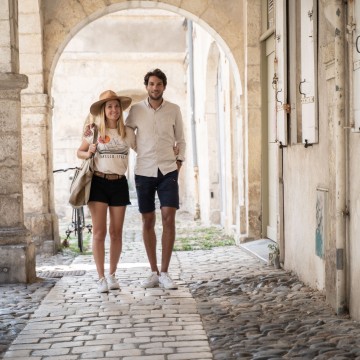 Couple marchant le long d'une rue à arcades